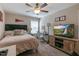 Inviting bedroom featuring a ceiling fan, an electric keyboard, large dresser and entertainment center with TV at 1025 Chelsea Run Ln, Apex, NC 27502