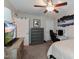 Bedroom with dark gray chest of drawers, desk with a black upholstered chair, and large television at 1025 Chelsea Run Ln, Apex, NC 27502