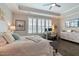 Spacious bedroom featuring a ceiling fan, tray ceiling, large window with plantation shutters and a work-from-home setup at 1025 Chelsea Run Ln, Apex, NC 27502