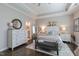 Bright bedroom with a dark wood floor, white furnishings, tray ceiling and a glimpse of the ensuite bath at 1025 Chelsea Run Ln, Apex, NC 27502