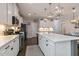 This spacious kitchen features an island with seating and storage, stainless appliances, and white cabinetry at 1025 Chelsea Run Ln, Apex, NC 27502