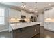 Beautiful kitchen features white cabinets, stainless steel appliances, gray island, and stylish pendant lighting at 1025 Chelsea Run Ln, Apex, NC 27502