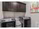 Laundry room with modern washer and dryer units, storage cabinets, and a flamingo art piece at 1025 Chelsea Run Ln, Apex, NC 27502