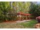 The backyard features a charming wood pergola, perfect for relaxation, with a hammock and lush greenery at 1100 Dotson Way, Apex, NC 27523