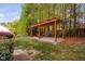 Backyard with a hammock under a pergola on a stone base surrounded by green grass and natural mulch at 1100 Dotson Way, Apex, NC 27523