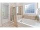 This bathroom features a tub, glass shower, and a window for natural light at 1100 Dotson Way, Apex, NC 27523