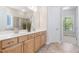 This bathroom features double sinks, a mirror, light-wood cabinets, and tile flooring at 1100 Dotson Way, Apex, NC 27523