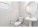 This half bathroom features a pedestal sink, toilet, and a window for natural light at 1100 Dotson Way, Apex, NC 27523