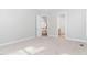 An empty bedroom with neutral walls and carpet with an open door to the hallway at 1100 Dotson Way, Apex, NC 27523