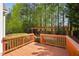 View of the wood deck and backyard featuring mature trees and a wooden structure at 1100 Dotson Way, Apex, NC 27523