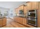 Modern kitchen with stainless steel appliances, light wood cabinets, and hardwood floors at 1100 Dotson Way, Apex, NC 27523