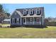 Charming home featuring a covered front porch, dormer windows, and manicured lawn at 117 Woodcroft Drive Dr, Angier, NC 27501