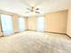 Large living room with neutral carpet, ceiling fan, and three windows dressed with sheer curtains at 117 Woodcroft Drive Dr, Angier, NC 27501
