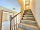 Carpeted stairway with wood railing leading to the upper level of the home at 117 Woodcroft Drive Dr, Angier, NC 27501