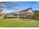 Backyard featuring a sunroom with a wooden deck, seamlessly integrated with a well-maintained lawn and landscaping at 1192 Princeton Kenly Rd, Kenly, NC 27542