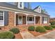 A lovely brick porch with black shutters and a welcoming front door with classic design at 1192 Princeton Kenly Rd, Kenly, NC 27542