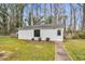 Side view of the white shed with a window and door, surrounded by green grass and landscaping at 1192 Princeton Kenly Rd, Kenly, NC 27542