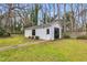 White shed with a single door and a barn door, nestled on a grassy lot with mature trees at 1192 Princeton Kenly Rd, Kenly, NC 27542