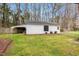 View of the white shed with a side awning, surrounded by green grass and mature trees at 1192 Princeton Kenly Rd, Kenly, NC 27542