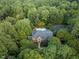 Aerial view showcases private estate with swimming pool and basketball court surrounded by dense trees at 12012 Six Forks Rd, Raleigh, NC 27614