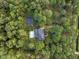 Picturesque aerial perspective of a house with pool, basketball court, nestled in a canopy of trees at 12012 Six Forks Rd, Raleigh, NC 27614