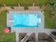 Aerial view of private pool with diving board surrounded by patio and lush landscaping at 12012 Six Forks Rd, Raleigh, NC 27614