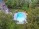 Aerial view of backyard featuring sparkling pool, lounge area, mature trees and basketball court at 12012 Six Forks Rd, Raleigh, NC 27614