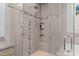 Detailed view of a bathroom's glass-enclosed shower with built-in shelves and tiled walls at 12012 Six Forks Rd, Raleigh, NC 27614