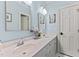 Bright bathroom featuring double sinks, white cabinets and light blue walls at 12012 Six Forks Rd, Raleigh, NC 27614