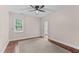 Cozy bedroom featuring hardwood floors, a ceiling fan, and a large window at 12012 Six Forks Rd, Raleigh, NC 27614