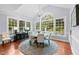 Sun-filled dining room features large windows, a contemporary chandelier, and seating for six, all bathed in natural light at 12012 Six Forks Rd, Raleigh, NC 27614