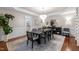 Neutral dining room with statement lighting fixture, a large mirror and dark wood floors under a large patterned rug at 12012 Six Forks Rd, Raleigh, NC 27614