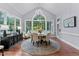 Bright dining room with natural light, a round table with seating, a modern chandelier, and hardwood floors at 12012 Six Forks Rd, Raleigh, NC 27614