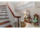 Inviting entryway with a wooden staircase and a decorative rug at 12012 Six Forks Rd, Raleigh, NC 27614