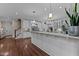 Open-concept kitchen with white cabinets, hardwood floors, stainless steel appliances, marble countertops, and large island at 12012 Six Forks Rd, Raleigh, NC 27614