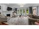 Bright living room with a fireplace, built-in bookshelves, and a wall of windows overlooking the outdoor space at 12012 Six Forks Rd, Raleigh, NC 27614