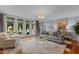 Bright living room boasts hardwood floors, neutral decor, multiple French doors, and access to a large outdoor deck at 12012 Six Forks Rd, Raleigh, NC 27614