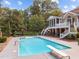 Sparkling swimming pool with diving board in backyard with screened in porch on house at 12012 Six Forks Rd, Raleigh, NC 27614