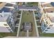 An aerial view displays a grassy courtyard space with a seating area between modern townhome buildings at 1218 Coach Station Alley # 101, Raleigh, NC 27601