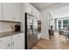 Modern kitchen with stainless steel appliances, white cabinets, and adjacent dining area at 1218 Coach Station Alley # 101, Raleigh, NC 27601