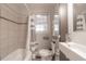 Modern bathroom with a shower-tub combo, updated sink and vanity, and neutral tile at 1301 Clarendon St, Durham, NC 27705