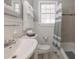 Bright bathroom features a window, white fixtures, and a shower with a striped curtain, offering a fresh and clean space at 1301 Clarendon St, Durham, NC 27705