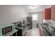 Compact kitchen featuring stainless steel appliances, dark countertops, and white tile flooring at 1301 Clarendon St, Durham, NC 27705