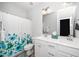 The bathroom features a floral shower curtain, a dual sink vanity, and a tiled floor at 1516 Barn Door Dr, Apex, NC 27502