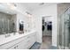Bathroom featuring dual sinks, a large mirror, and a walk-in closet for ample storage at 1516 Barn Door Dr, Apex, NC 27502