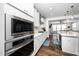 Modern kitchen with stainless steel appliances and white cabinets opens to living area at 1516 Barn Door Dr, Apex, NC 27502