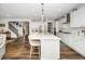 Spacious kitchen with large center island, white cabinetry, modern appliances, and hardwood floors at 1516 Barn Door Dr, Apex, NC 27502