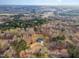 Scenic aerial view of the charming home nestled among the trees with a long circular driveway at 205 Fox Hollow Dr, Clayton, NC 27527