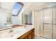 Bathroom with skylight, double sinks, a shower and wood-look floors at 205 Fox Hollow Dr, Clayton, NC 27527