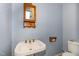 Charming bathroom featuring patterned wallpaper, a pedestal sink, and a classic medicine cabinet at 205 Fox Hollow Dr, Clayton, NC 27527
